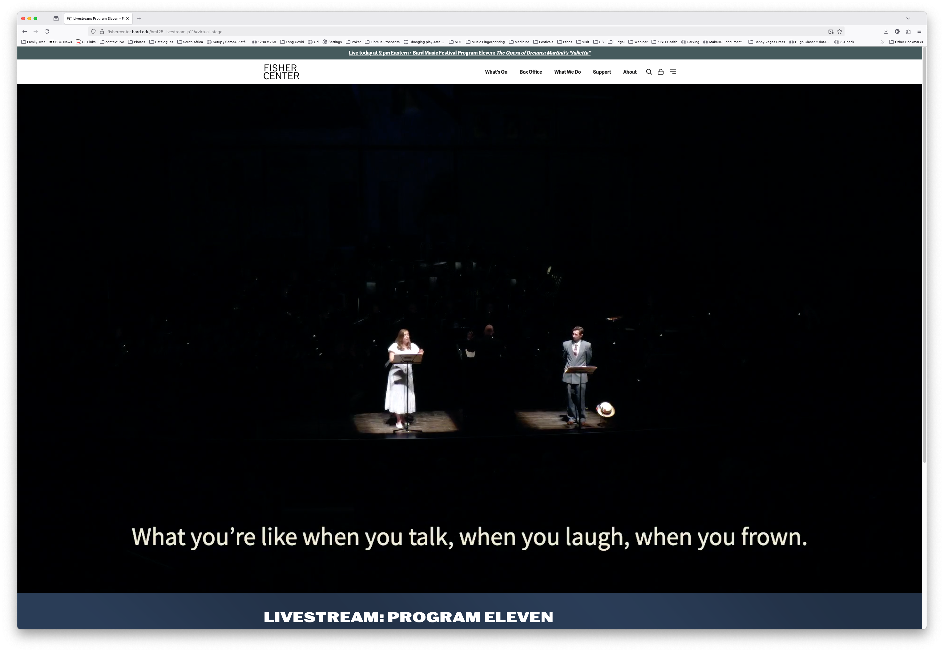 A livestream performance on the Fisher Center website shows two performers standing on stage at music stands, one in a white dress and the other in a grey suit. White subtitle text at the bottom reads: “What you’re like when you talk, when you laugh, when you frown.” The website header displays the Fisher Center logo and navigation links.